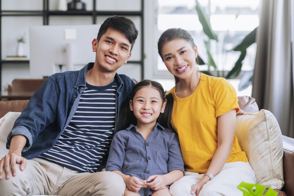 happiness young asian family dad mom and daughter casual relax sitting smile spending peaceful moment together on sofa couch in living room at home,casual cloth family enjoy weekend morning apartment